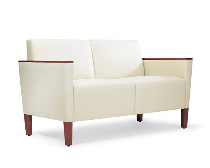 A three-quarter view of a Brava Classic Lounge Settee with white textile and wood arm caps.