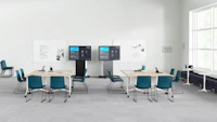 Peacock Pronta Stacking Chairs in a corporate learning space with flip-top tables, AVVC One media displays, and glass white boards.