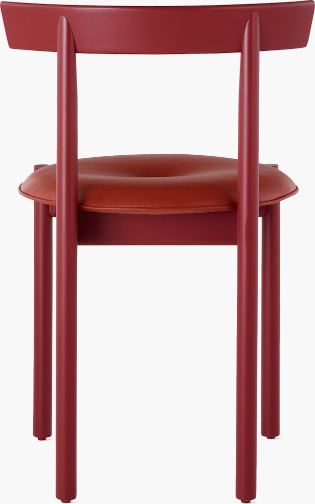 A red Comma Chair with a seat pad, viewed from the back.