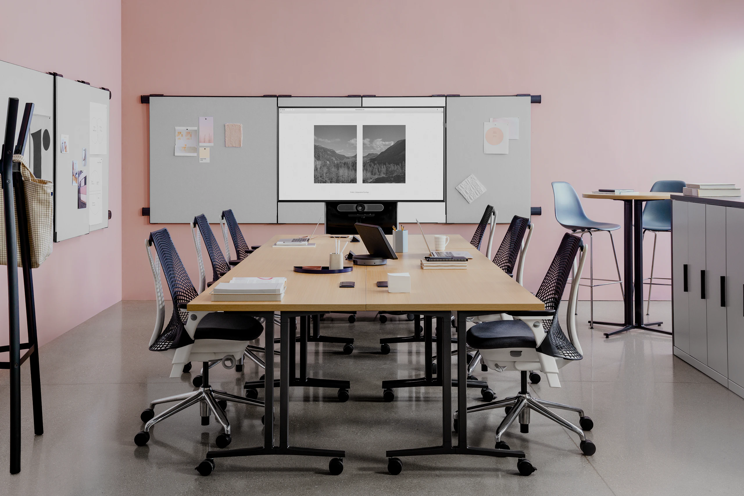 Meeting tables in a Workshop Setting with locker storage and project work pinned on boards attached to the walls.