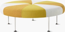 A Girard Color Wheel Ottoman upholstered in yellow fabrics, viewed from the side.