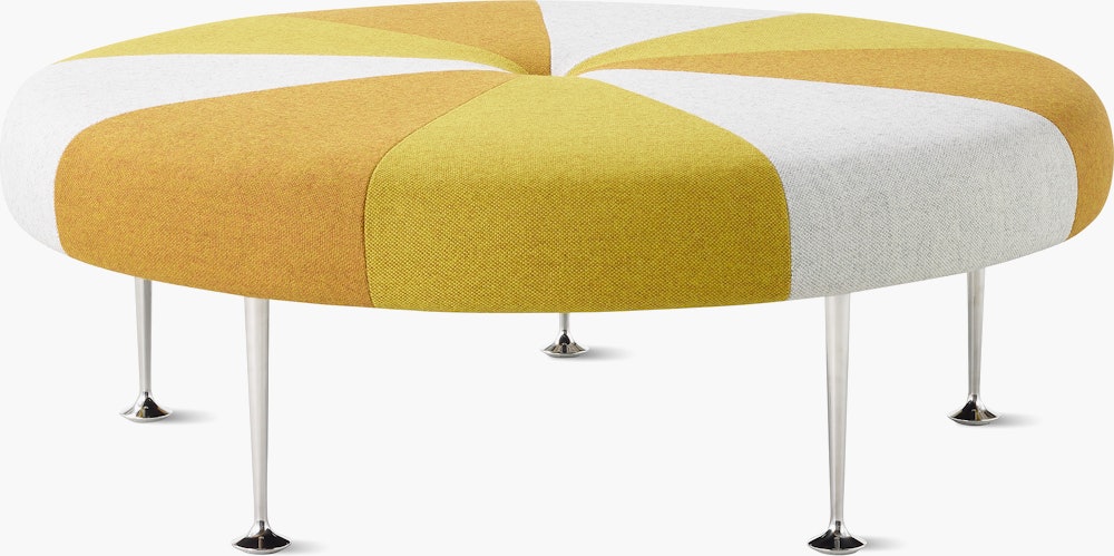 A Girard Color Wheel Ottoman upholstered in yellow fabrics, viewed from the side.