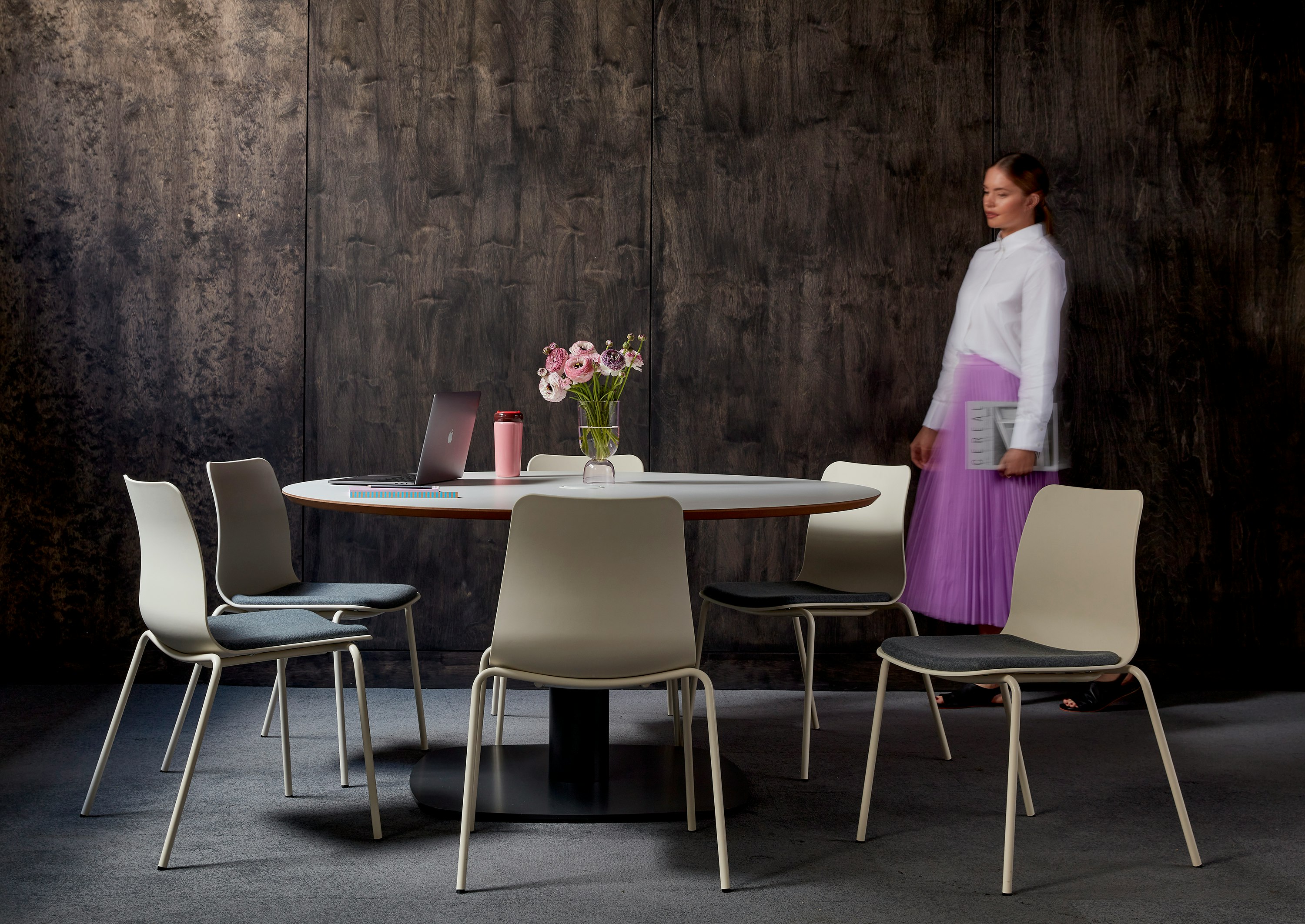 Cluster of Polly chairs sitting around a circular Megaped table, set against a wooden wall.