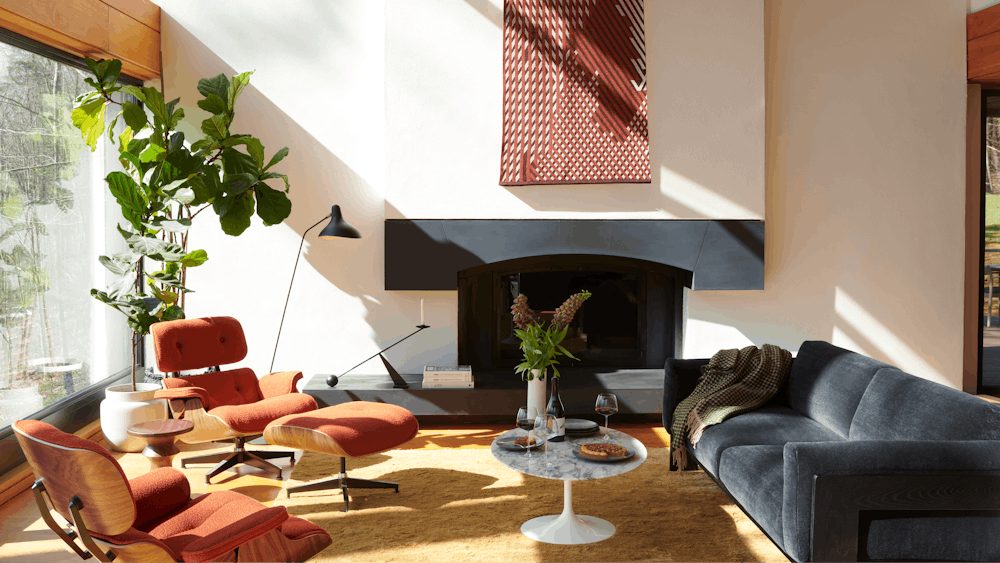 Bastiano Sofa,  Saarinen Coffee Table,  Ruti Moroccan Wool Rug,  Serge Mouille Floor Lamp,  ,  Eames Lounge Chair and Ottoman,  Risk Knit Wall Hanging,  Eames Walnut Stool,   Interconnect Candle Holder