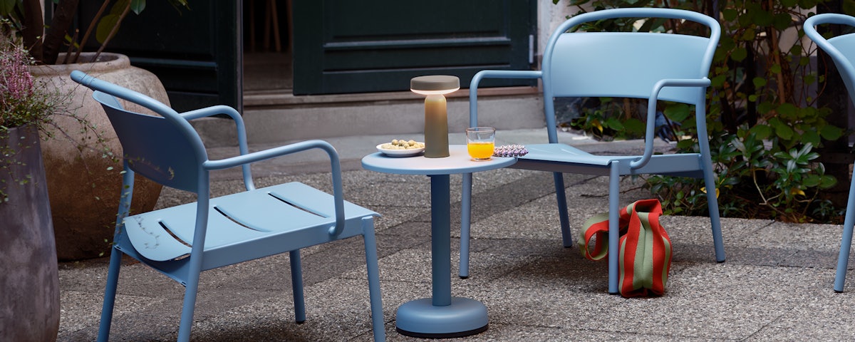 A Linear Steel Coffee Table and Two Linear Steel Lounge Chairs in an outdoor patio setting