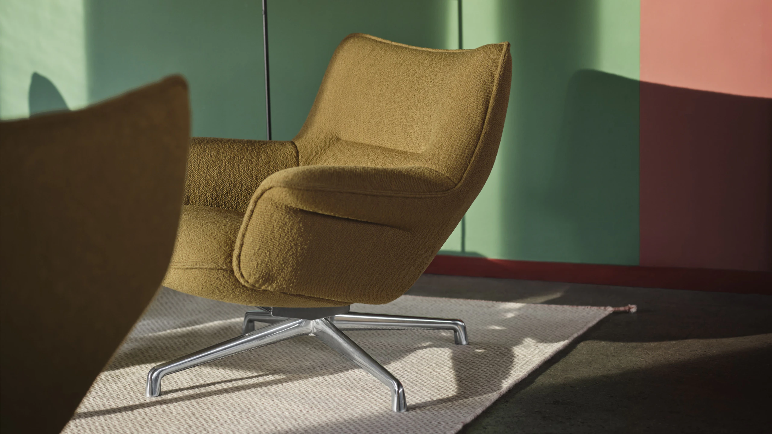 A Muuto Doze Lounge Chair Low Back Swivel Base in Heath 8/Polished Aluminum on a Ply Rug in Light Rose next to a Black Tip Floor Lamp