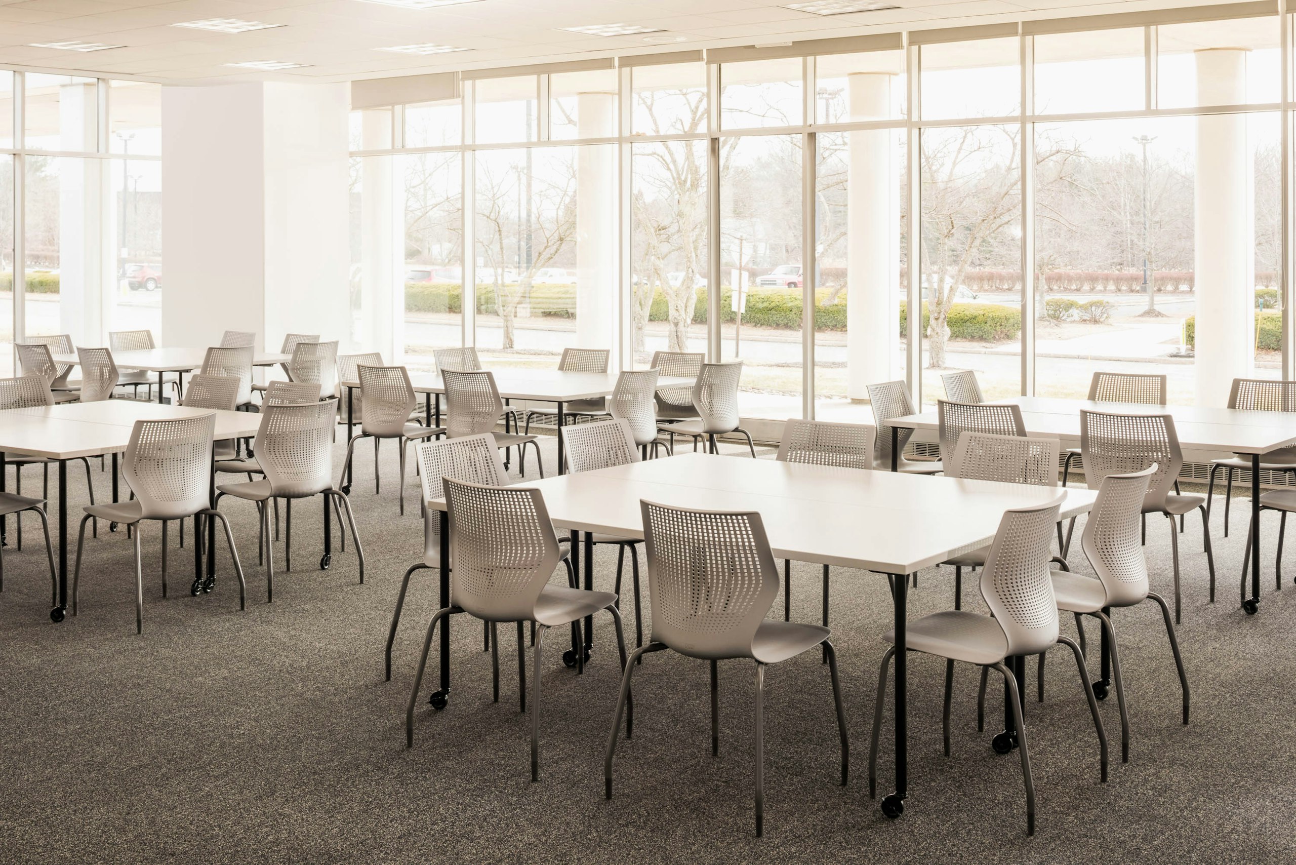 Knoll Antenna simple tables with black legs and MultiGeneration by Knoll chairs for a café