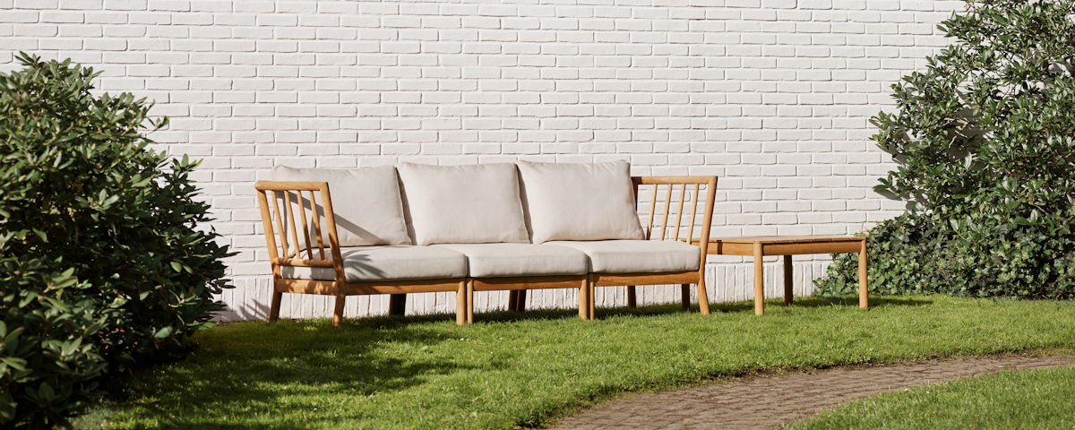 Tradition Outdoor Three Seater Sofa with Tradition Outdoor Table in an outdoor lawn setting
