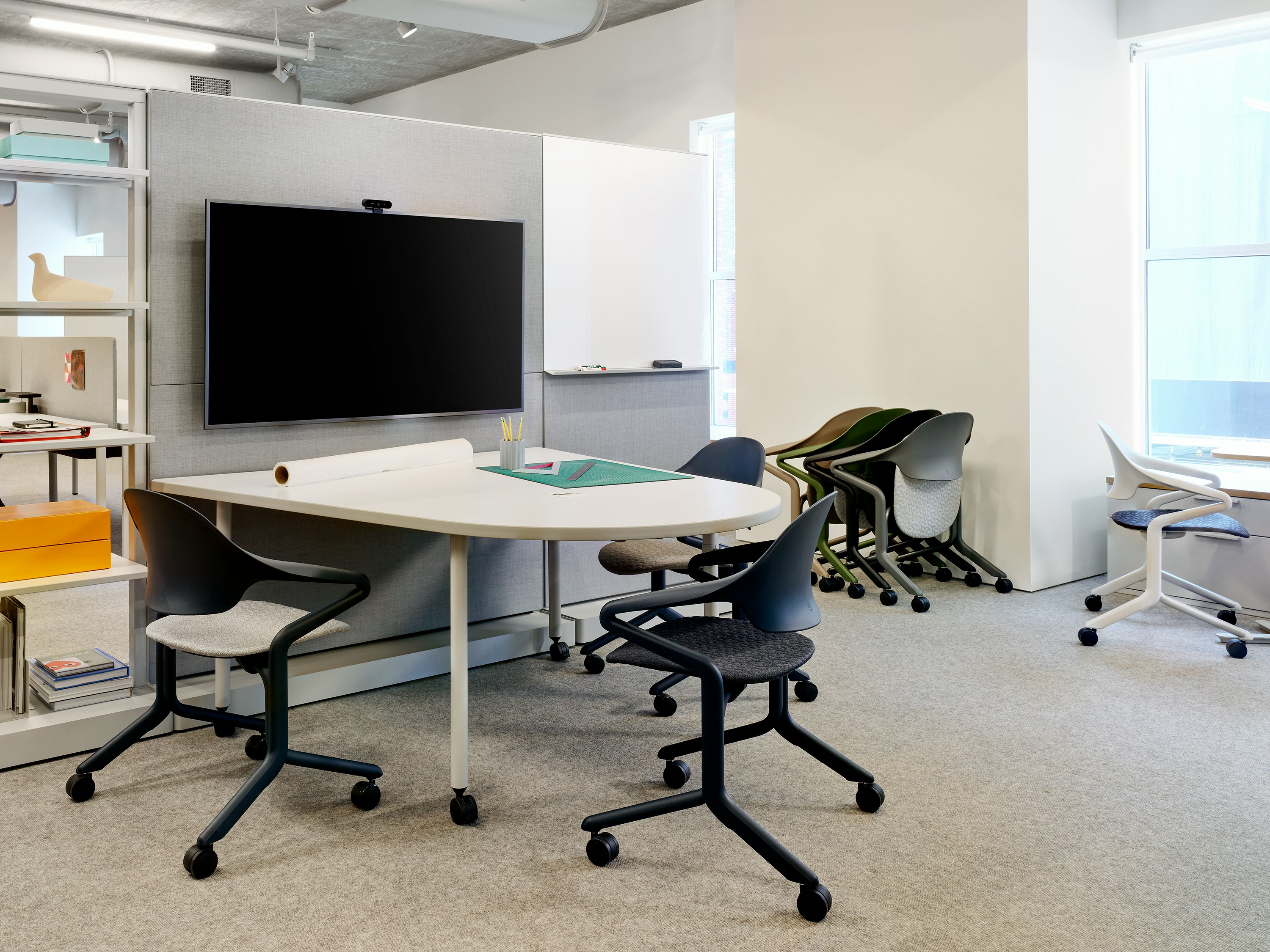 Fuld Nesting Chairs shown at a table and nested against the wall