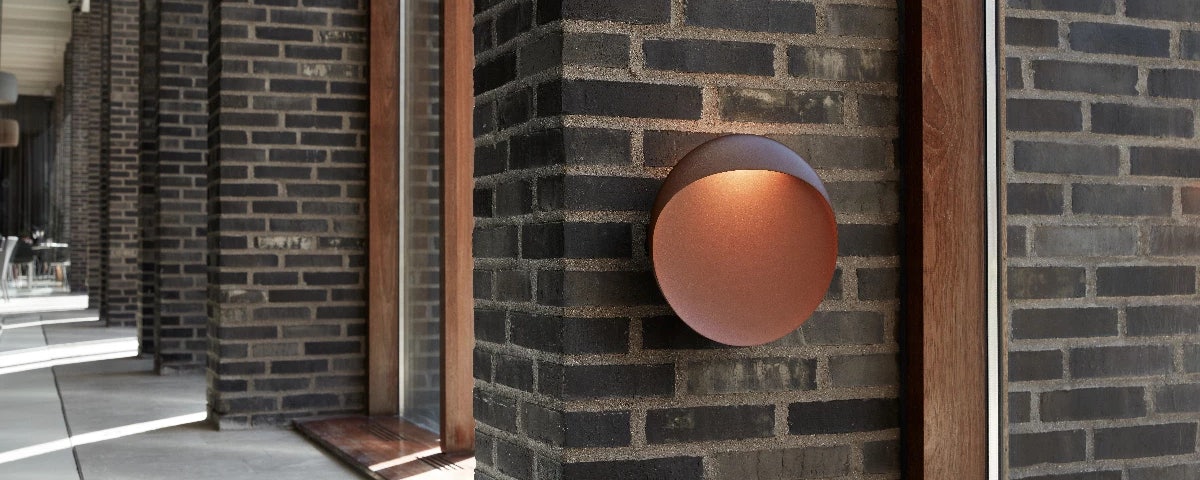 Flindt Wall Lamp on a brick pillar in a residential hallway setting