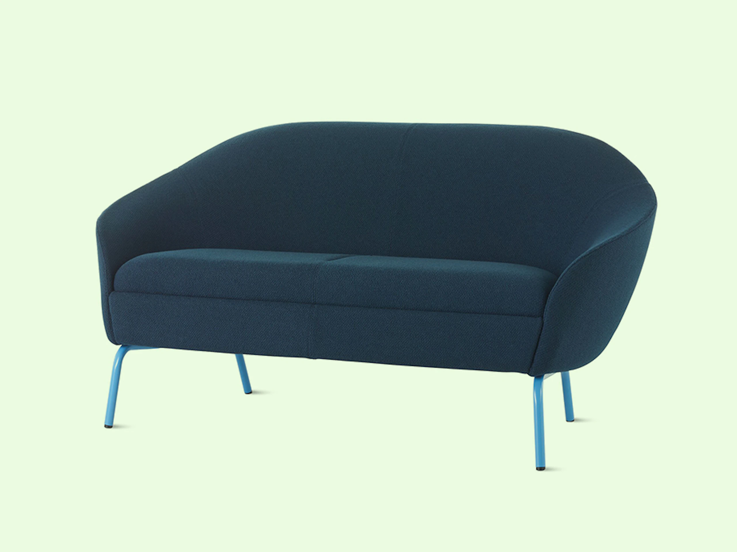 NaughtOne's Ever Sofa in blue upholstery and with light blue legs, over a mint colored background.