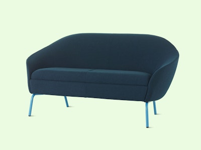NaughtOne's Ever Sofa in blue upholstery and with light blue legs, over a mint coloured background.
