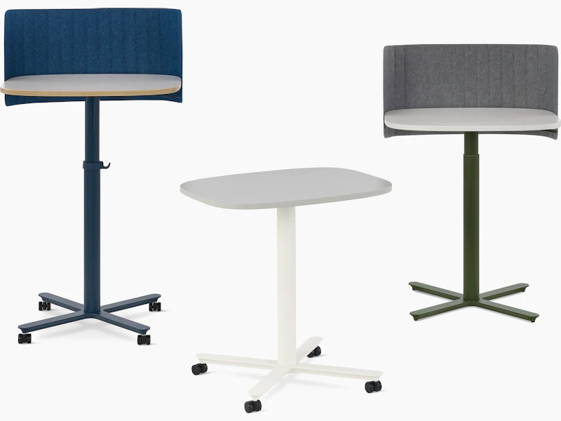 Multiple large Passport Work Tables shown with white and light grey tops and a variety of base colors and accessories.