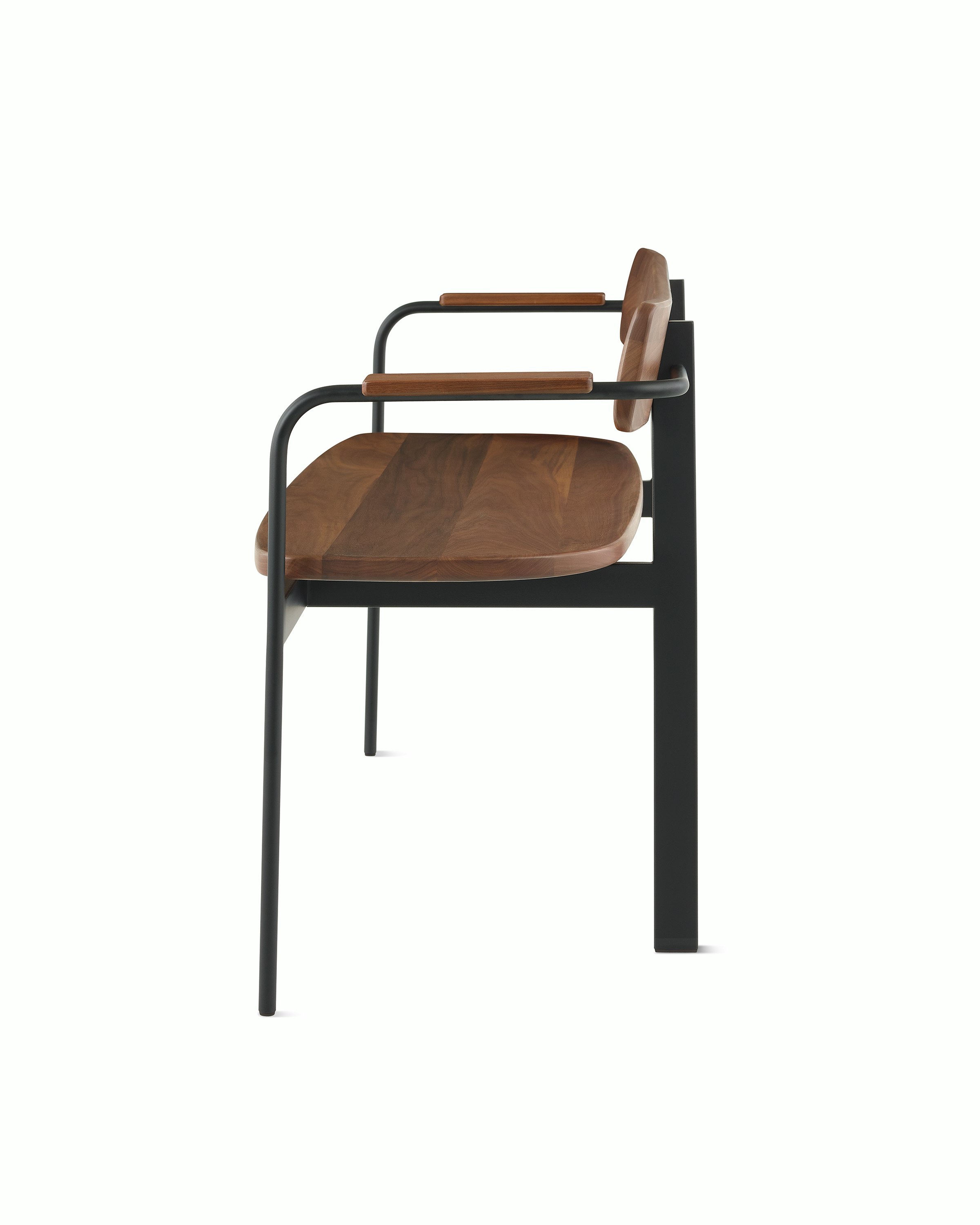 A Betwixt Bench with walnut seat, backrest, and arms with a black frame. 
