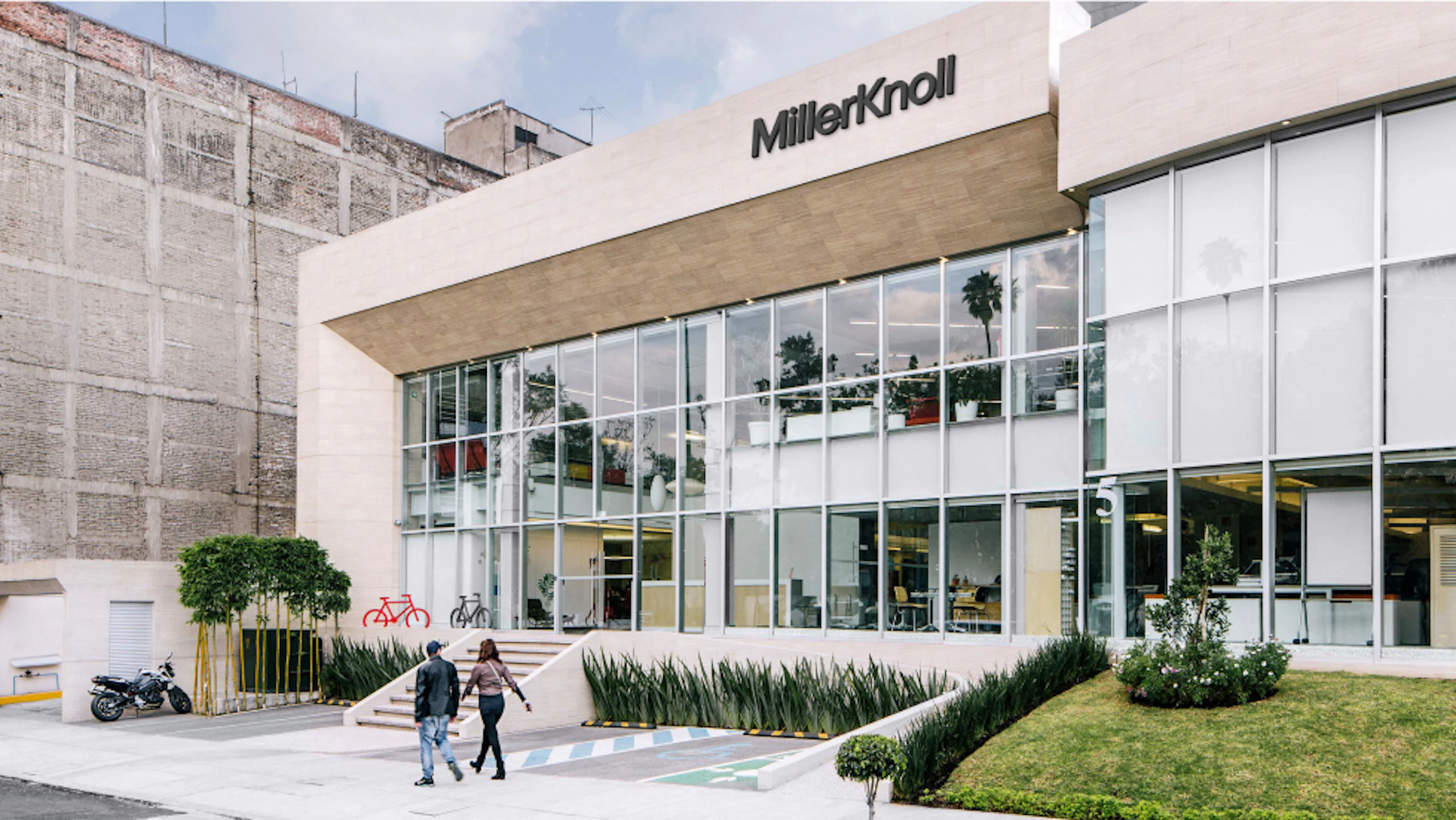 Two people walking past the MillerKnoll Mexico City showroom