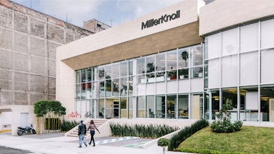 Two people walking past the MillerKnoll Mexico City showroom