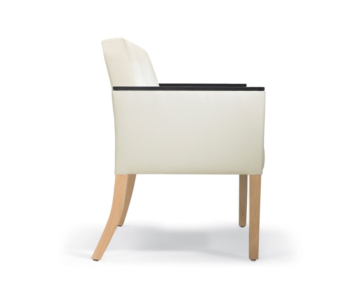 A side view of Brava 862 Plus Chair in white textile with urethane arm caps and maple legs.
