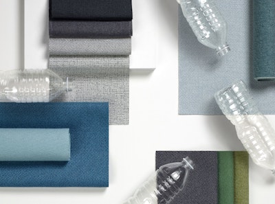 Revenio textiles displayed on a table with clear bottles.