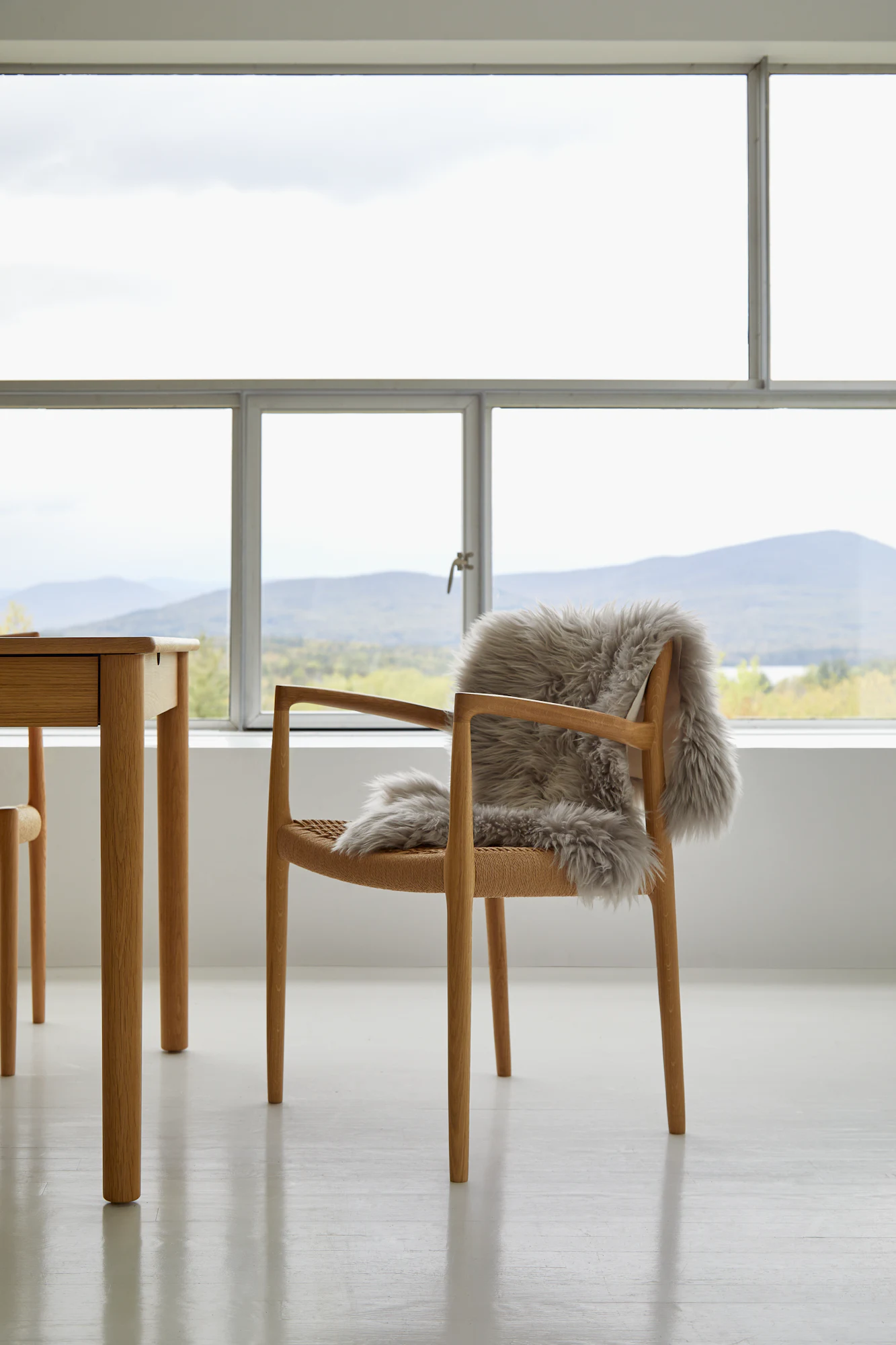 Moller Model 57 armchair in walnut with ivory leather seat near windows