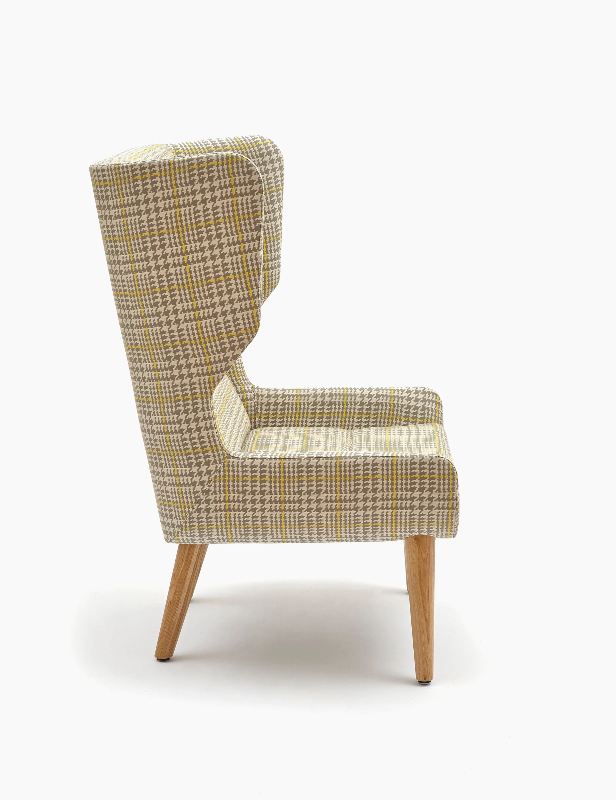 An off-white Hush Chair with a gray and yellow pattern and wooden base, viewed from the side.