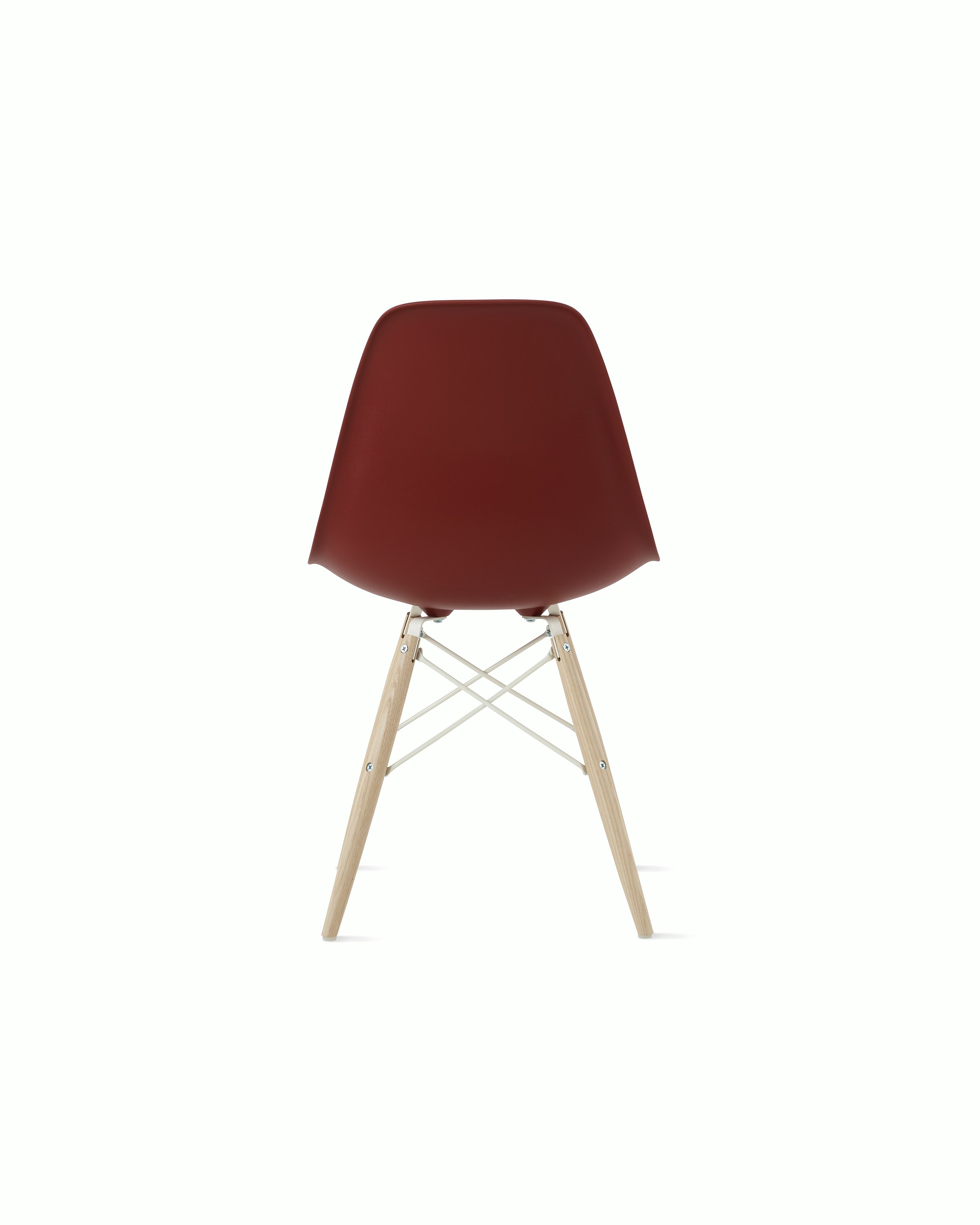 Back of brick red plastic shell chair with dowel base.