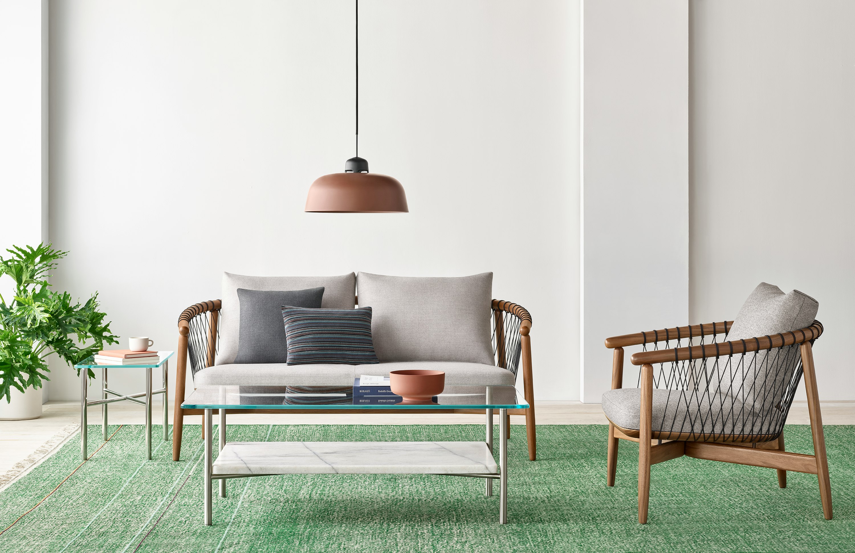 A casual lounge setting with a Layer Table anchoring a Crosshatch Settee and Crosshatch Chair.