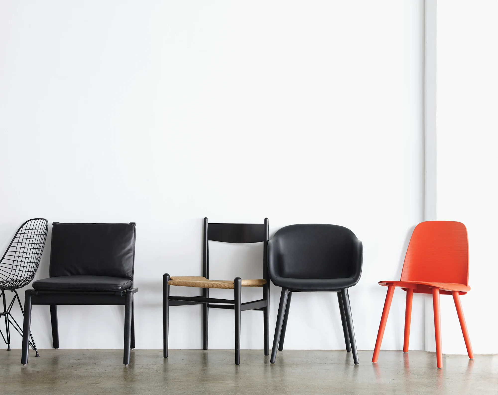 Nerd Chair-style dining chairs shown in black and orange variants together.