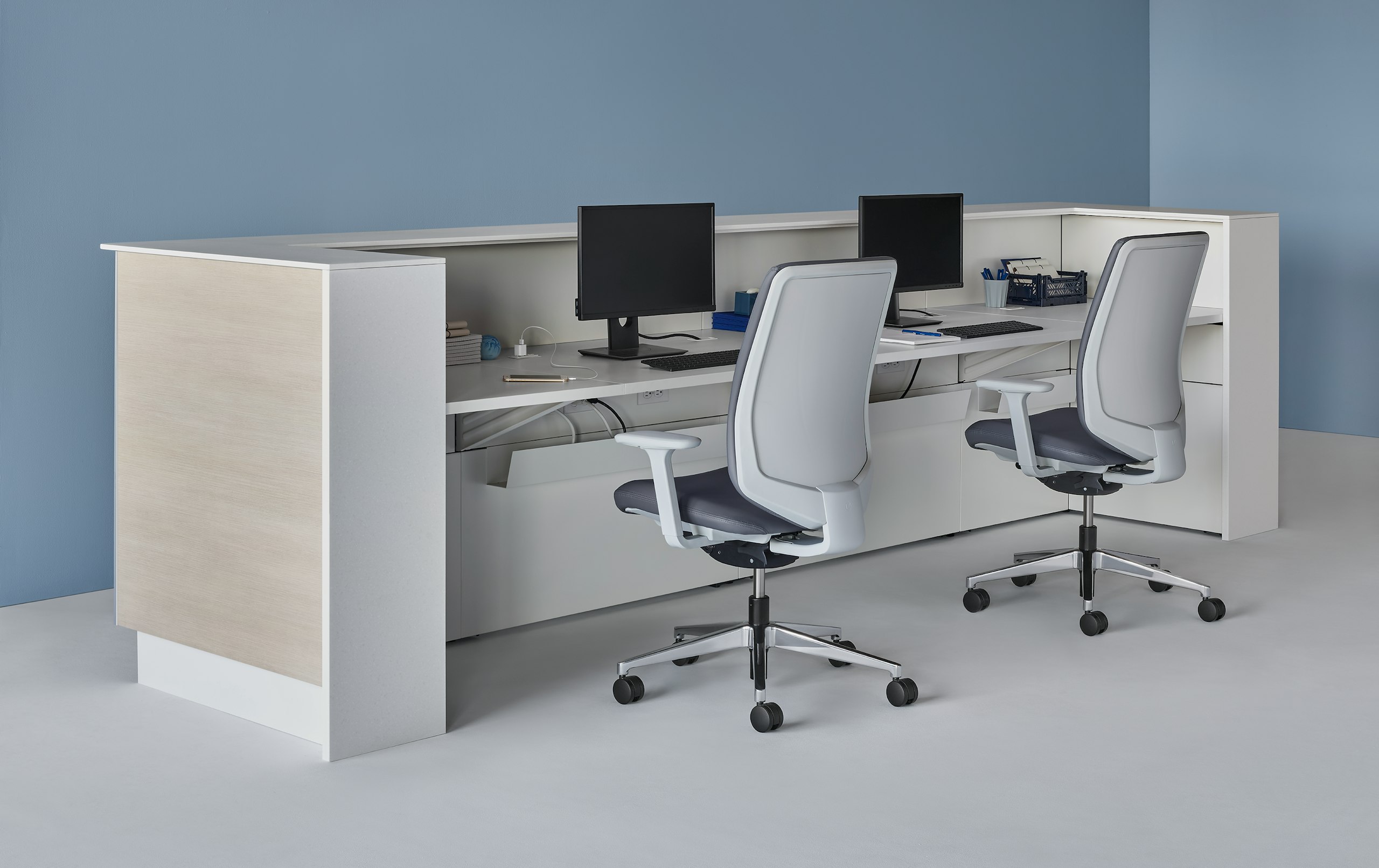 Prefab Commend Nurses Station for two with light woodgrain laminate fronts and white Corian transaction surfaces, Verus Chairs, and monitor stands.
