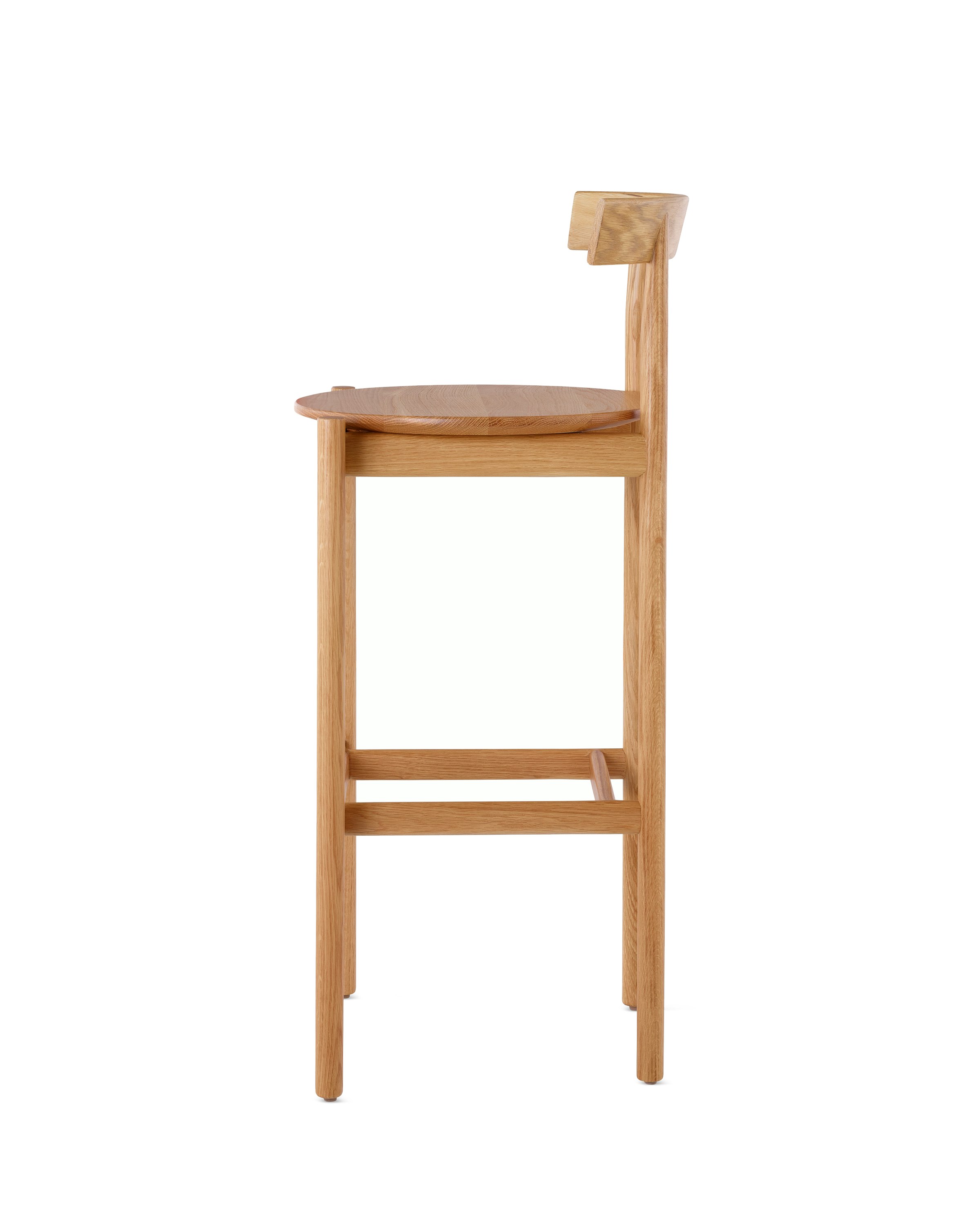 Profile view of an oak bar-height Comma Stool.