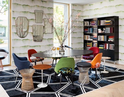 Brightly coloured Saarinen Executive Chair surrounding a black dining room table.