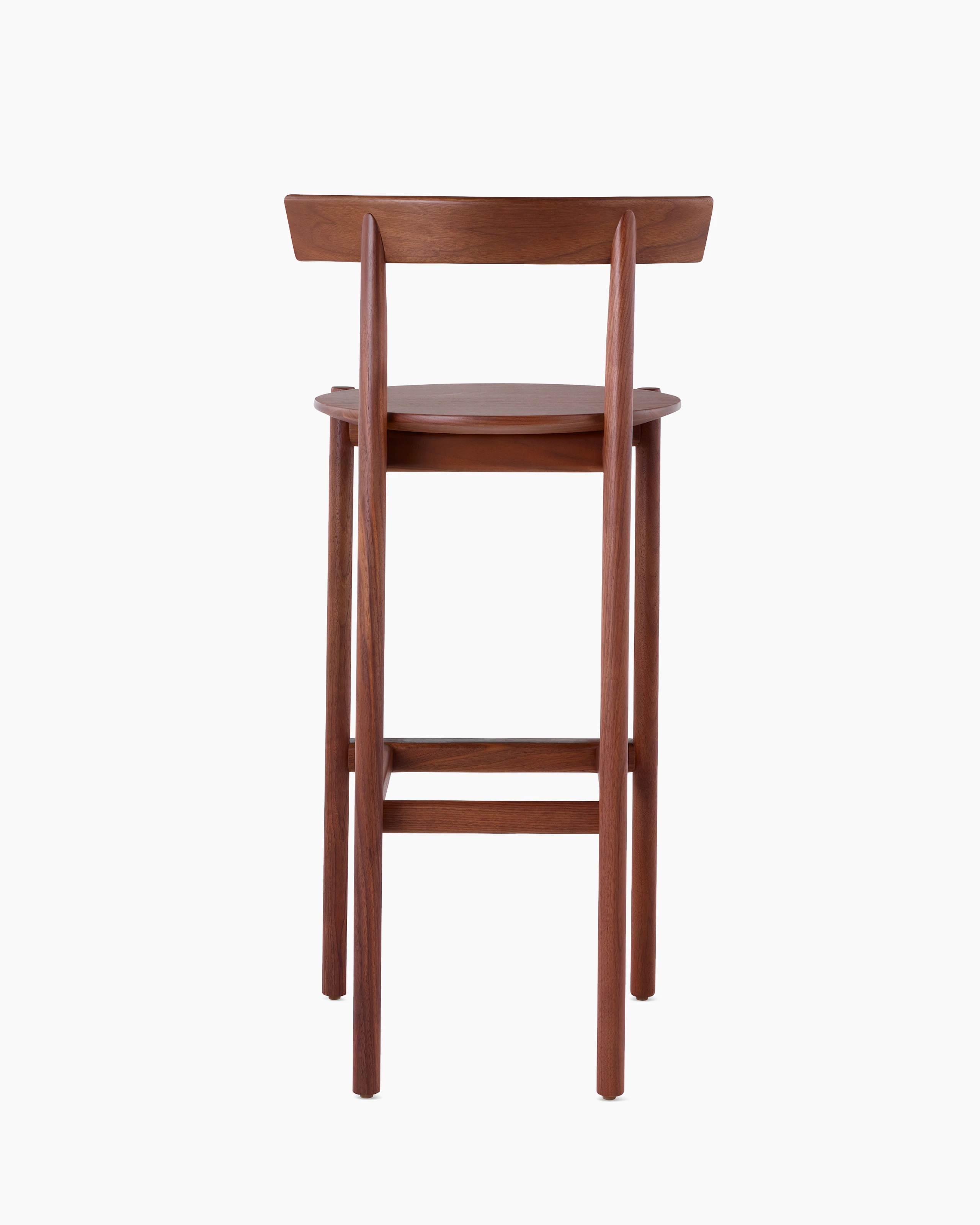 A walnut bar-height Comma Stool, viewed from the back.
