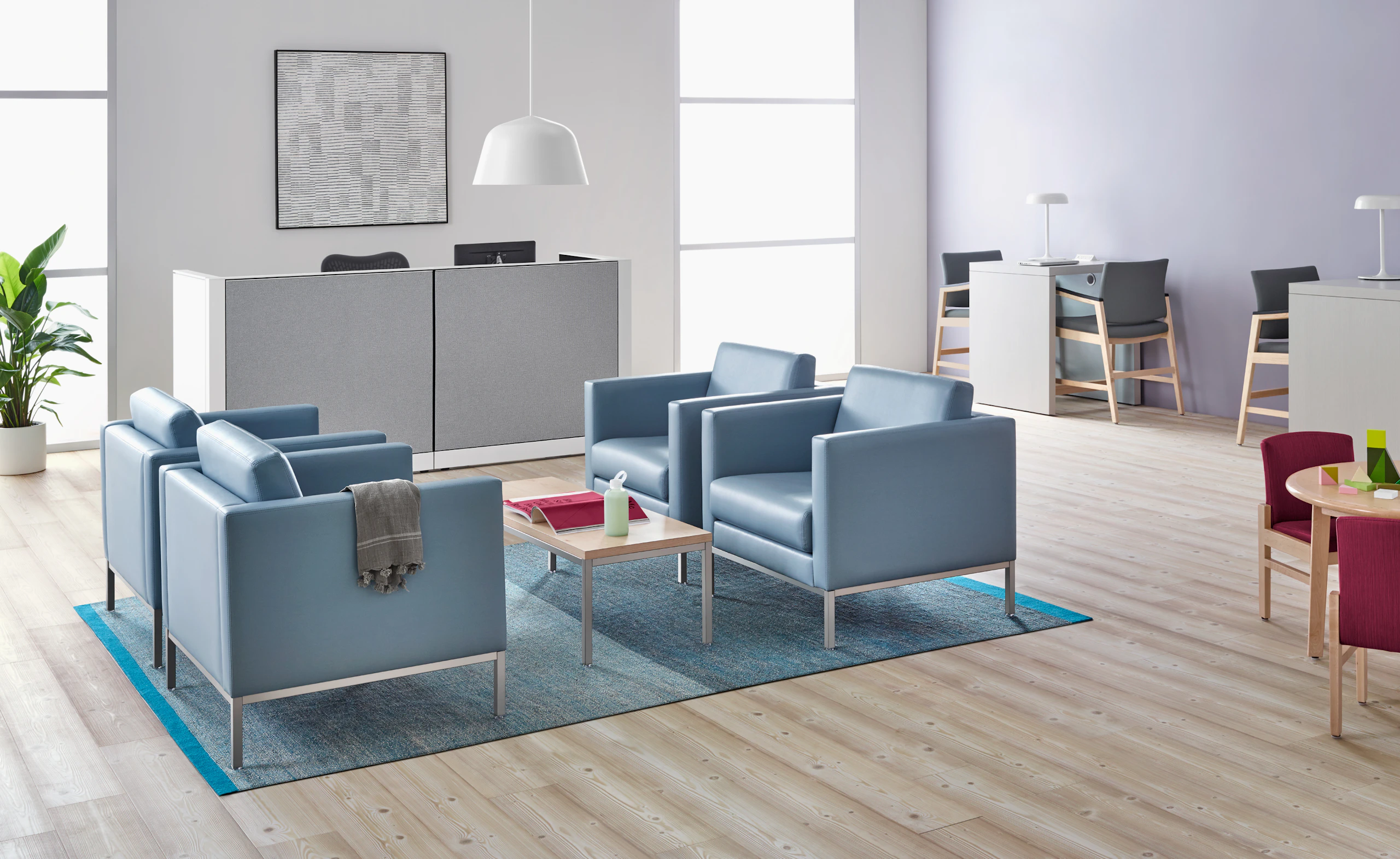 A well-lit waiting room featuring Riva lounge chairs in blue textile with brushed metal legs and Monarch Easy Access Chairs.