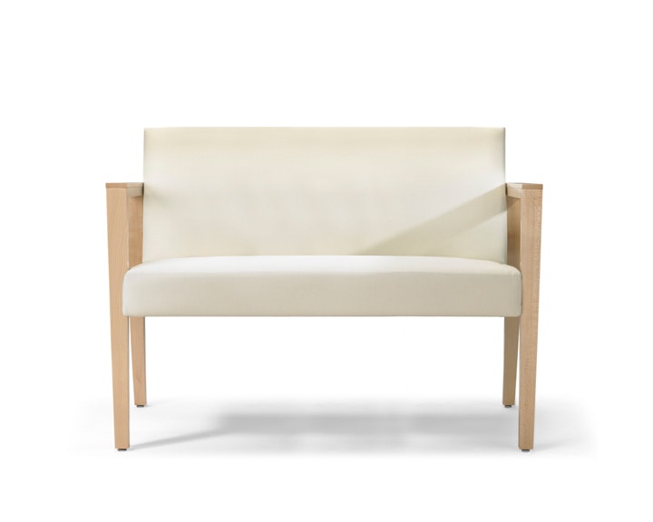 A front view of a Brava 863 plus chair in white textile with open maple wood arms.