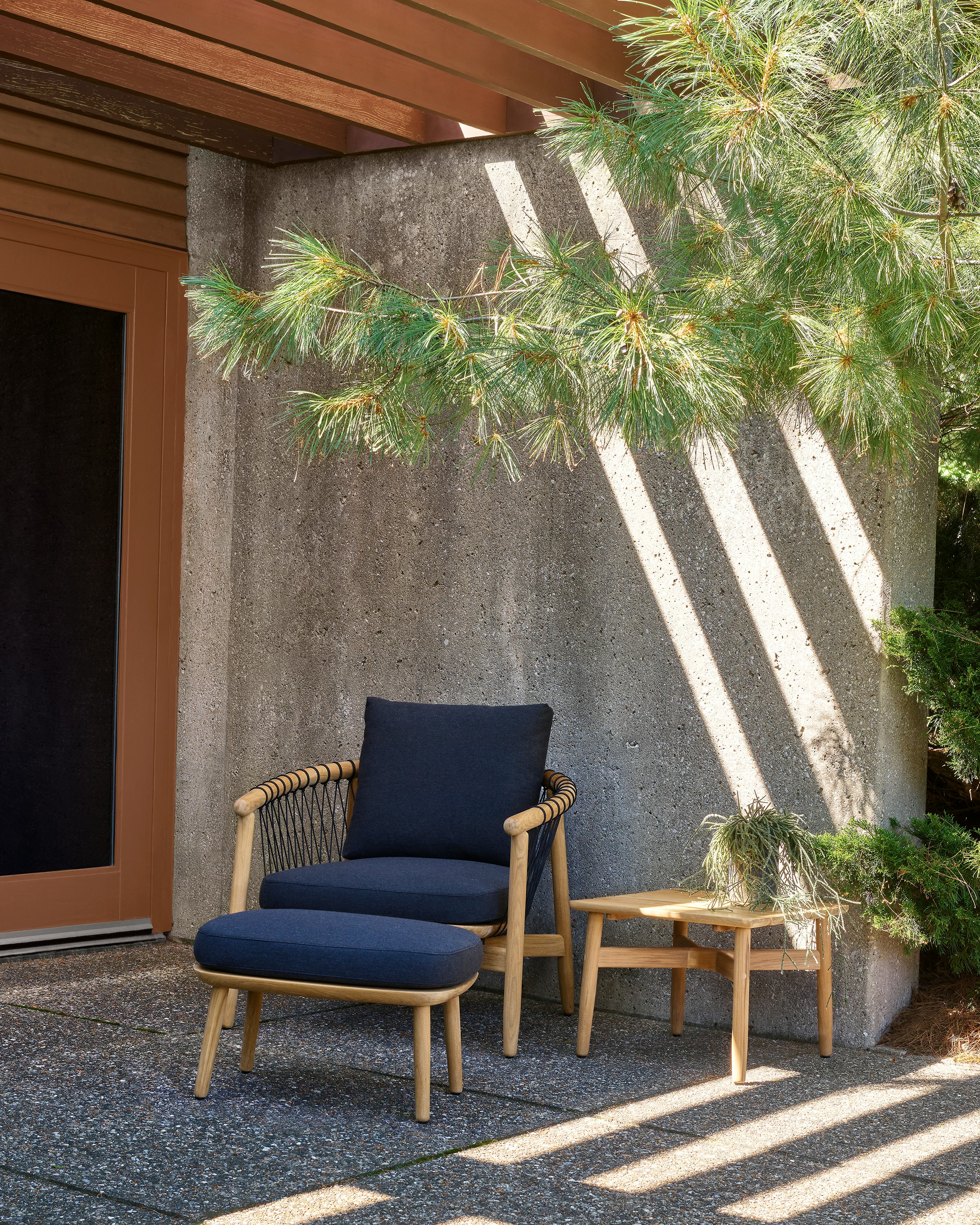 Crosshatch Outdoor Lounge Chair and Ottoman with side square table in an environmental setting.