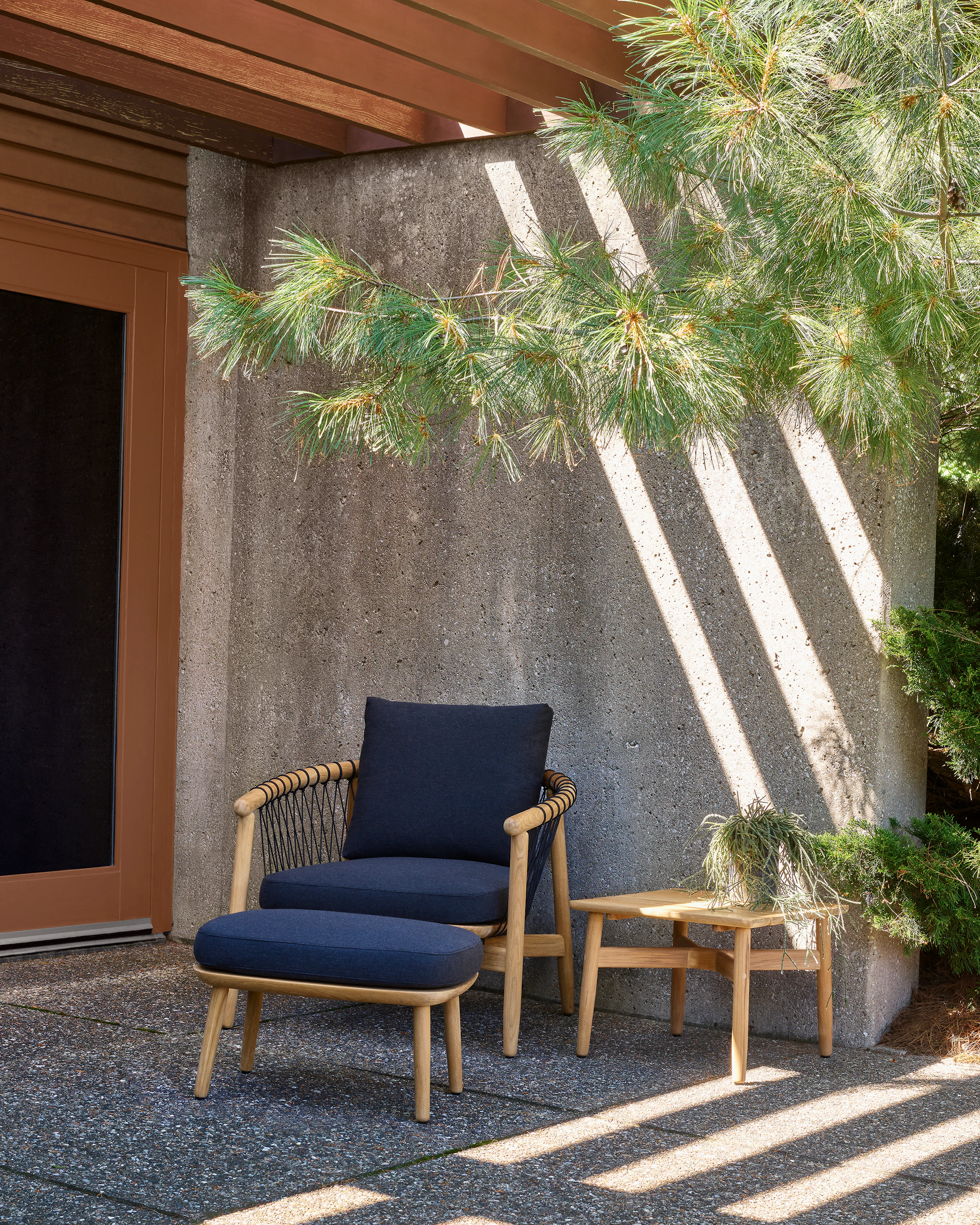 Crosshatch Outdoor Lounge Chair and Ottoman with side square table in an environmental setting.