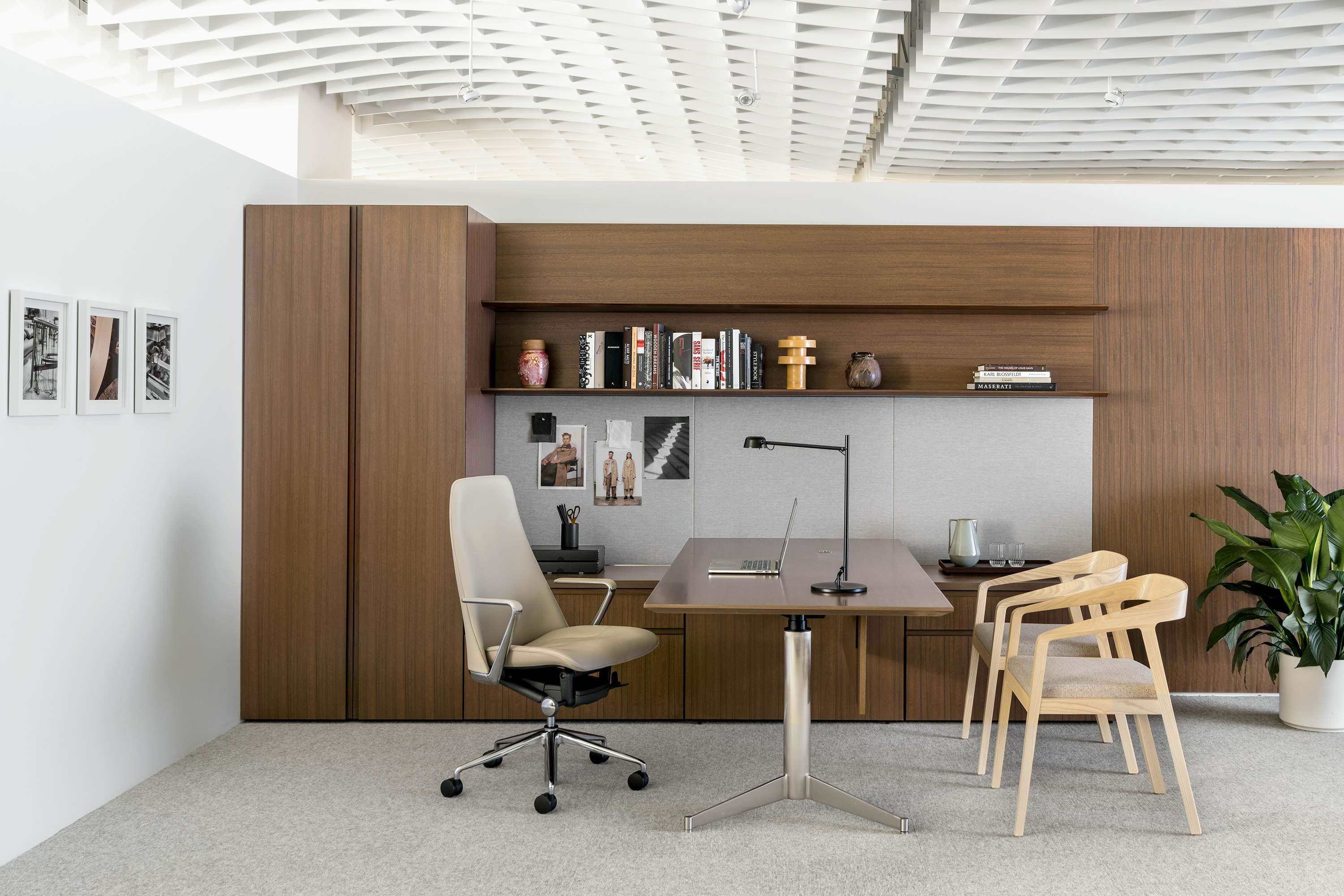 A private office featuring Geiger Levels Casegoods with a medium wood finish, a beige leather Taper executive chair, and two Full Twist Guest Chairs.