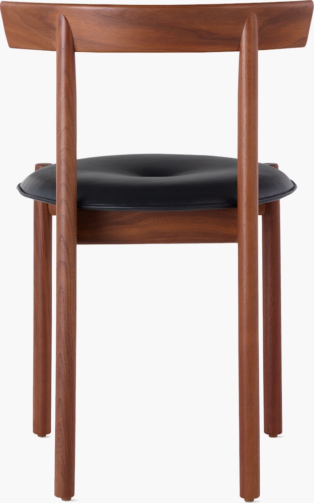 A walnut Comma Chair with a seat pad, viewed from the back.