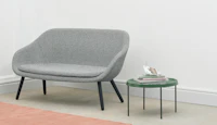 A grey About A Lounge Sofa next to a green table.