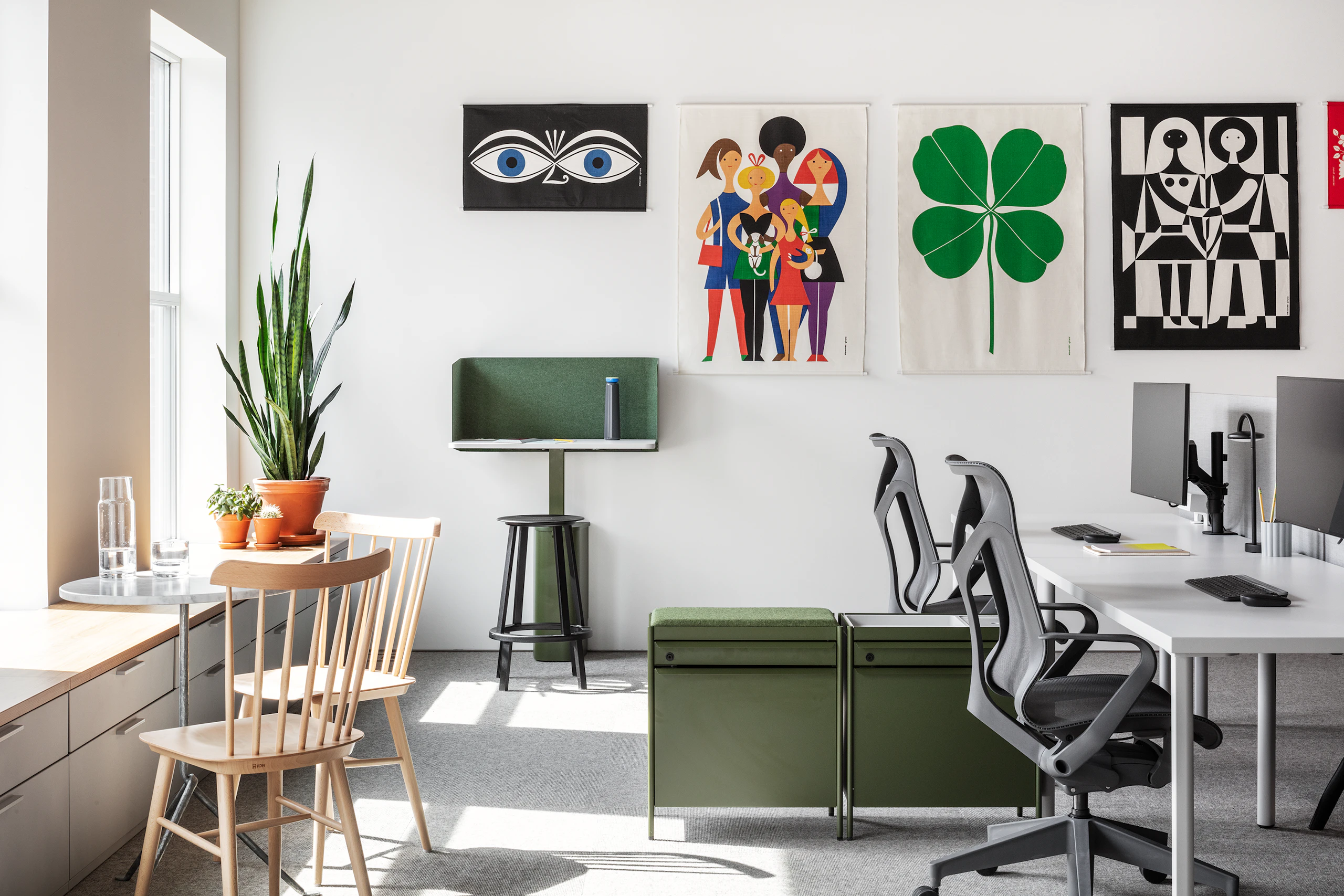 An office setting with Girard Environmental Enrichment panels on the walls, a pair of Cosm Chairs, and Everywhere Tables with monitors on monitor arms.
