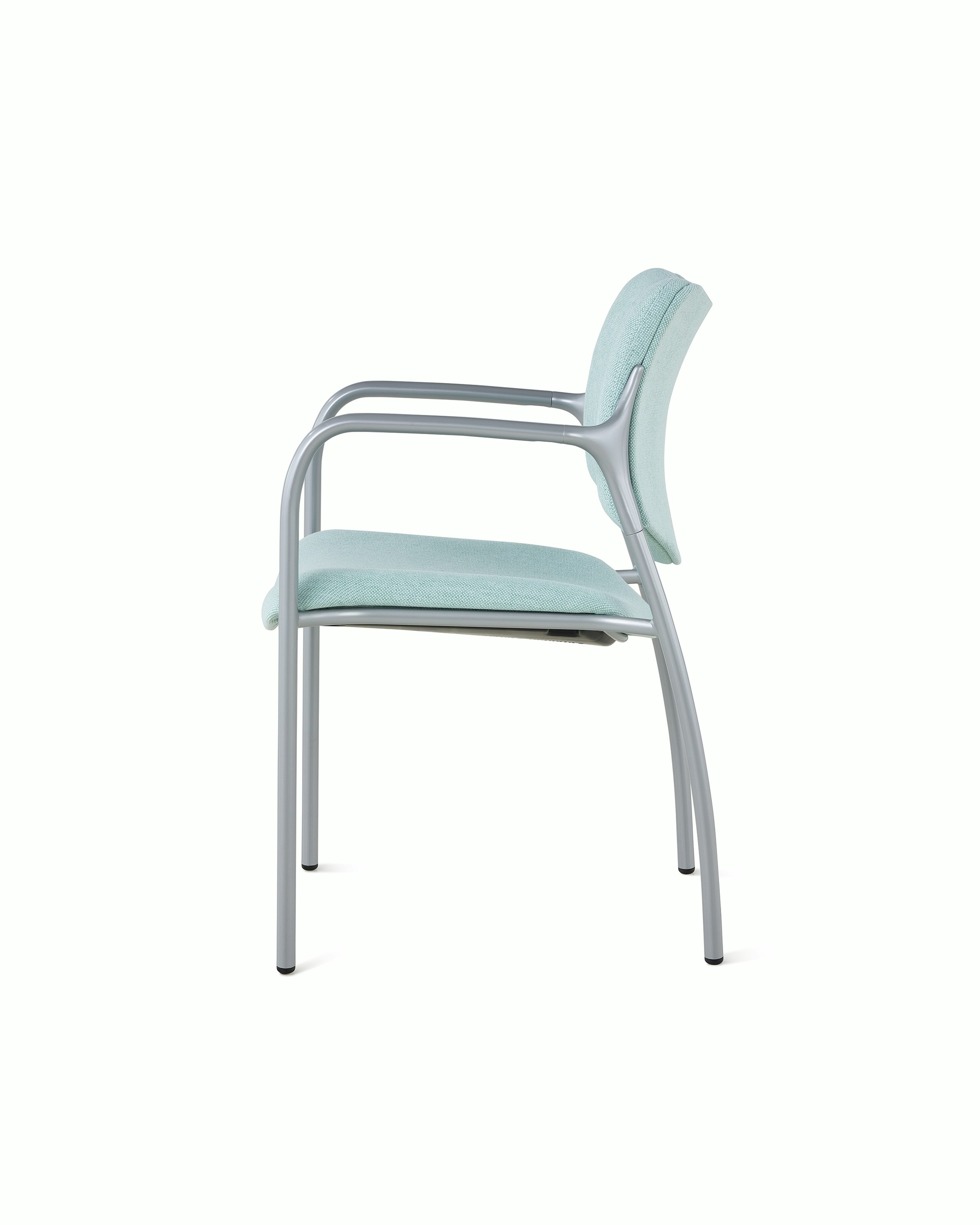 An Aside Chair with light green upholstered seat and back, viewed from the side.