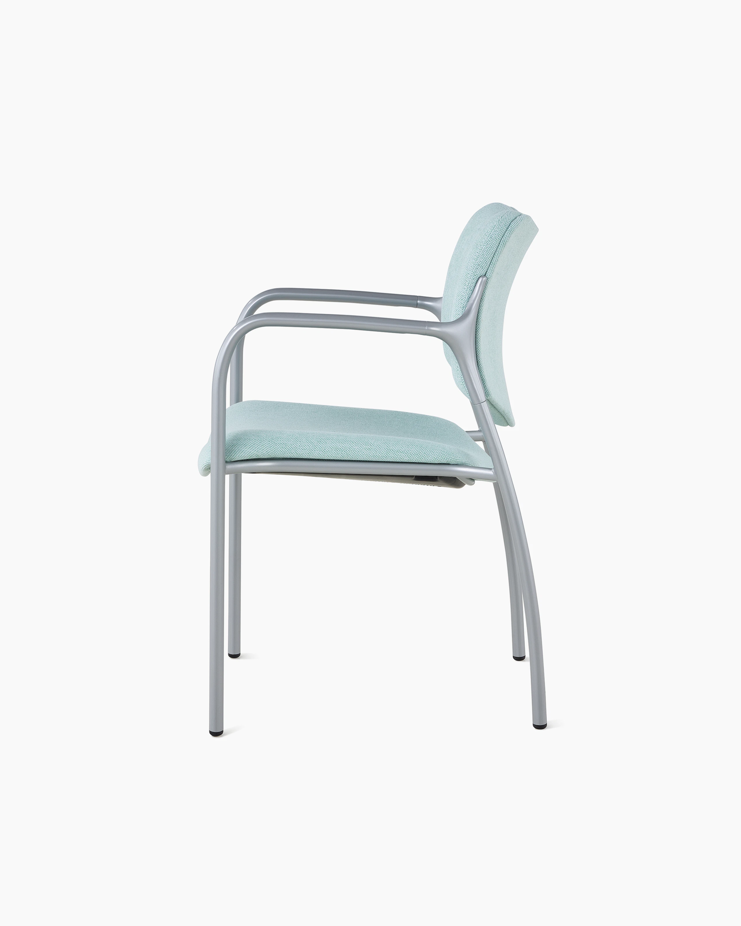 An Aside Chair with light green upholstered seat and back, viewed from the side.