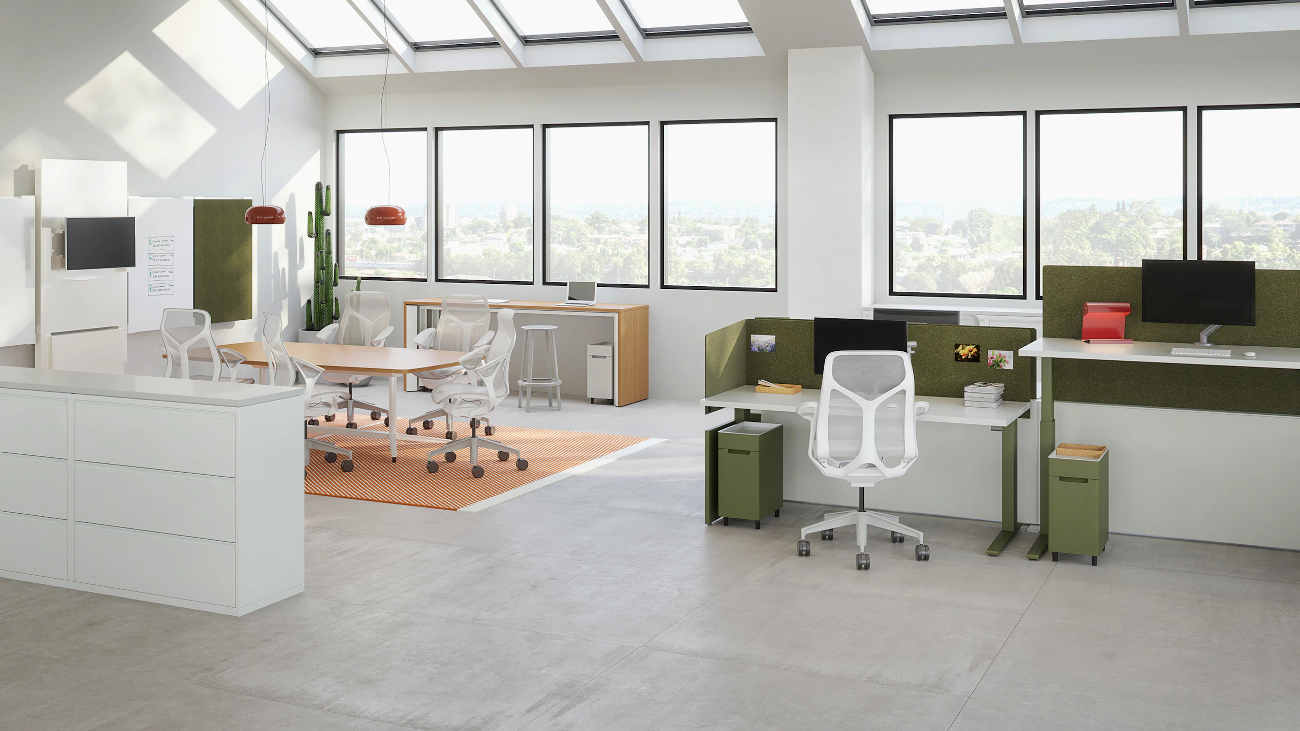 Small workspace view featuring height-adjustable table workspaces with Ambit Workspace Solutions in olive color, a six person meeting table, and standing height table against the windows.
