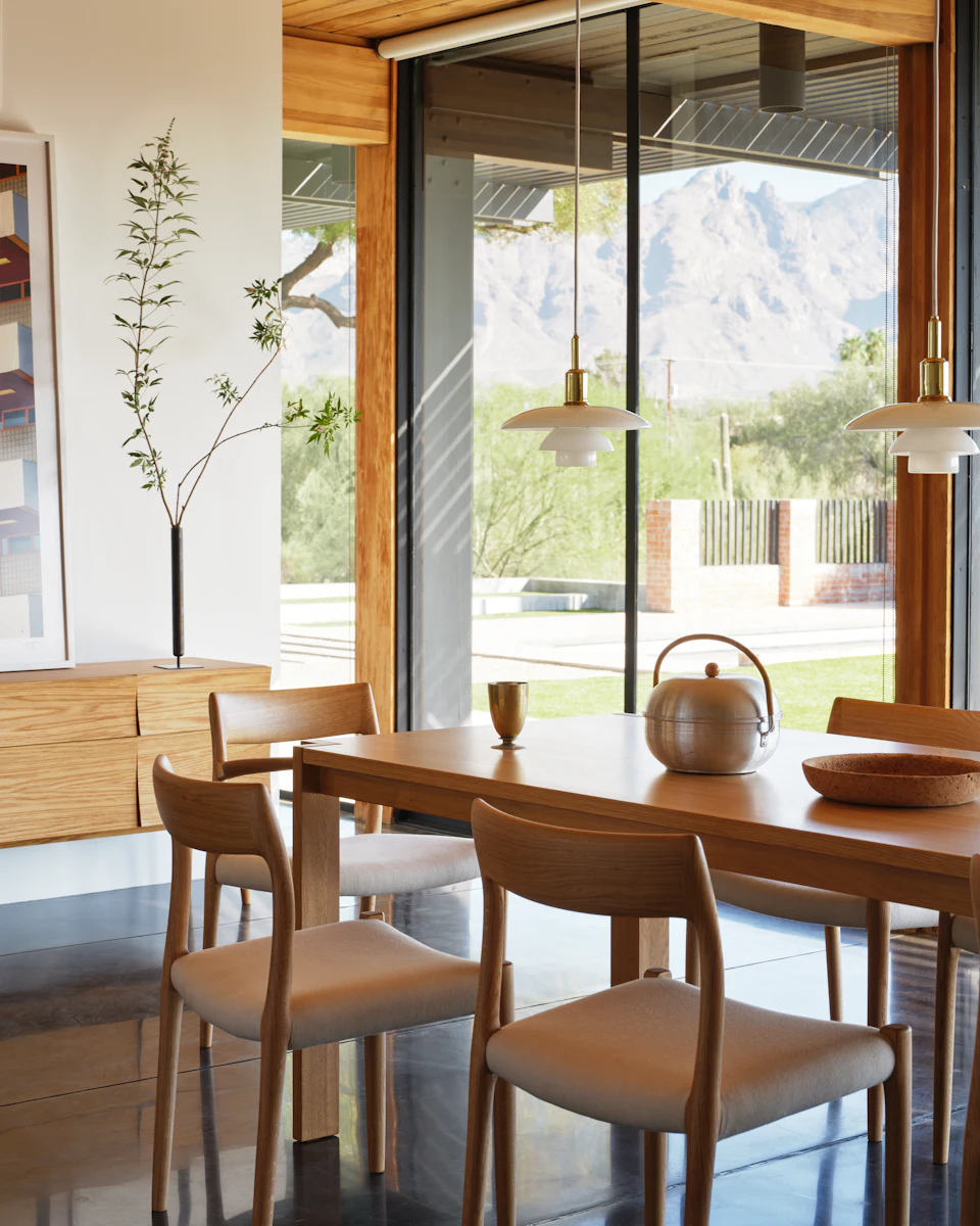 Wood dining table with chairs and a teapot in a bright modern dining room