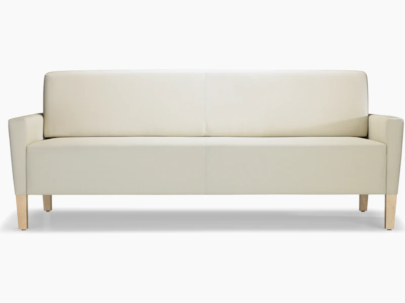 A front view of a Brava Flop Sofa in white textile with maple legs.