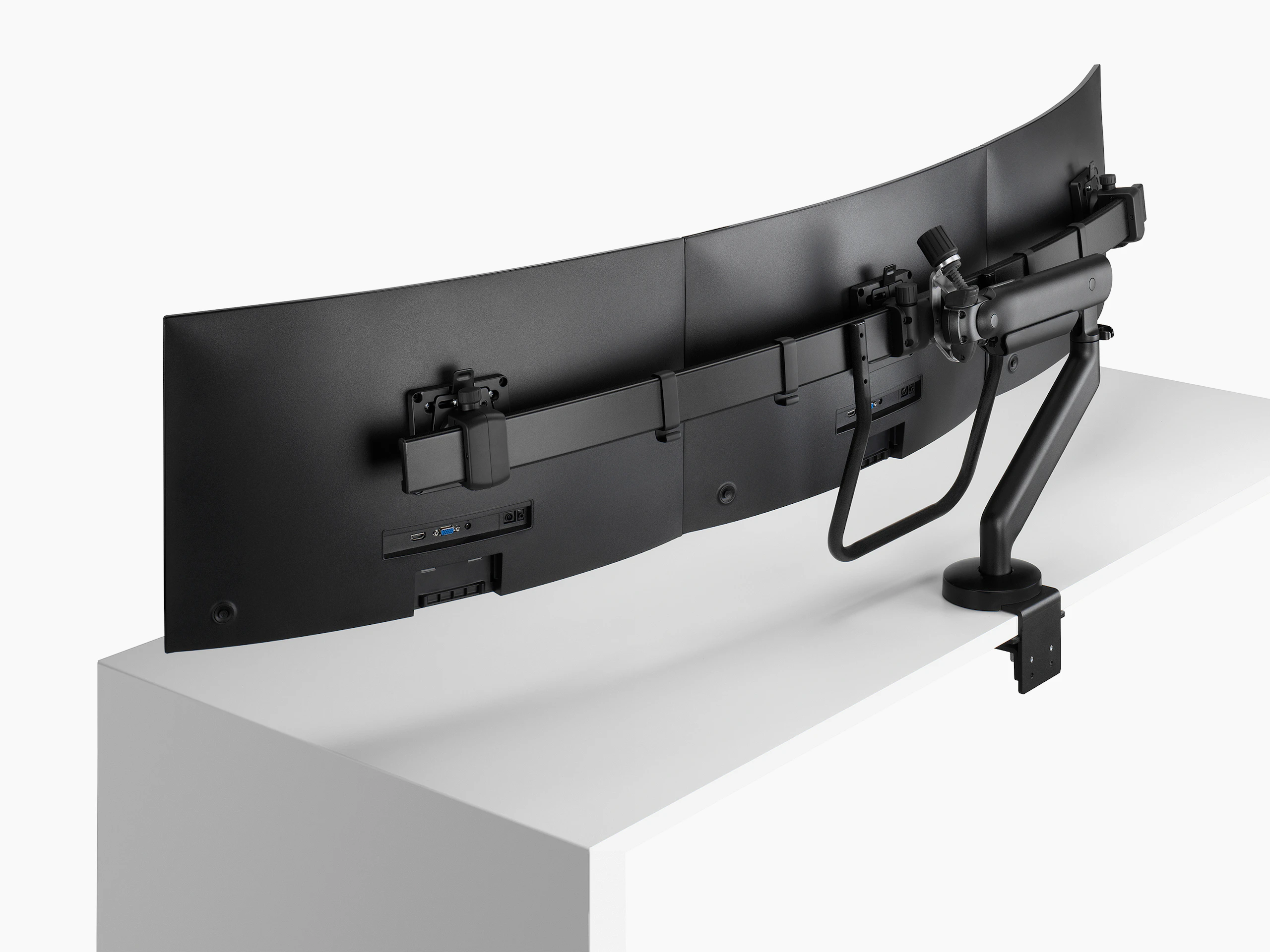 Black Flo X triple monitor arm set up with 27'' screens, viewed from the side-back