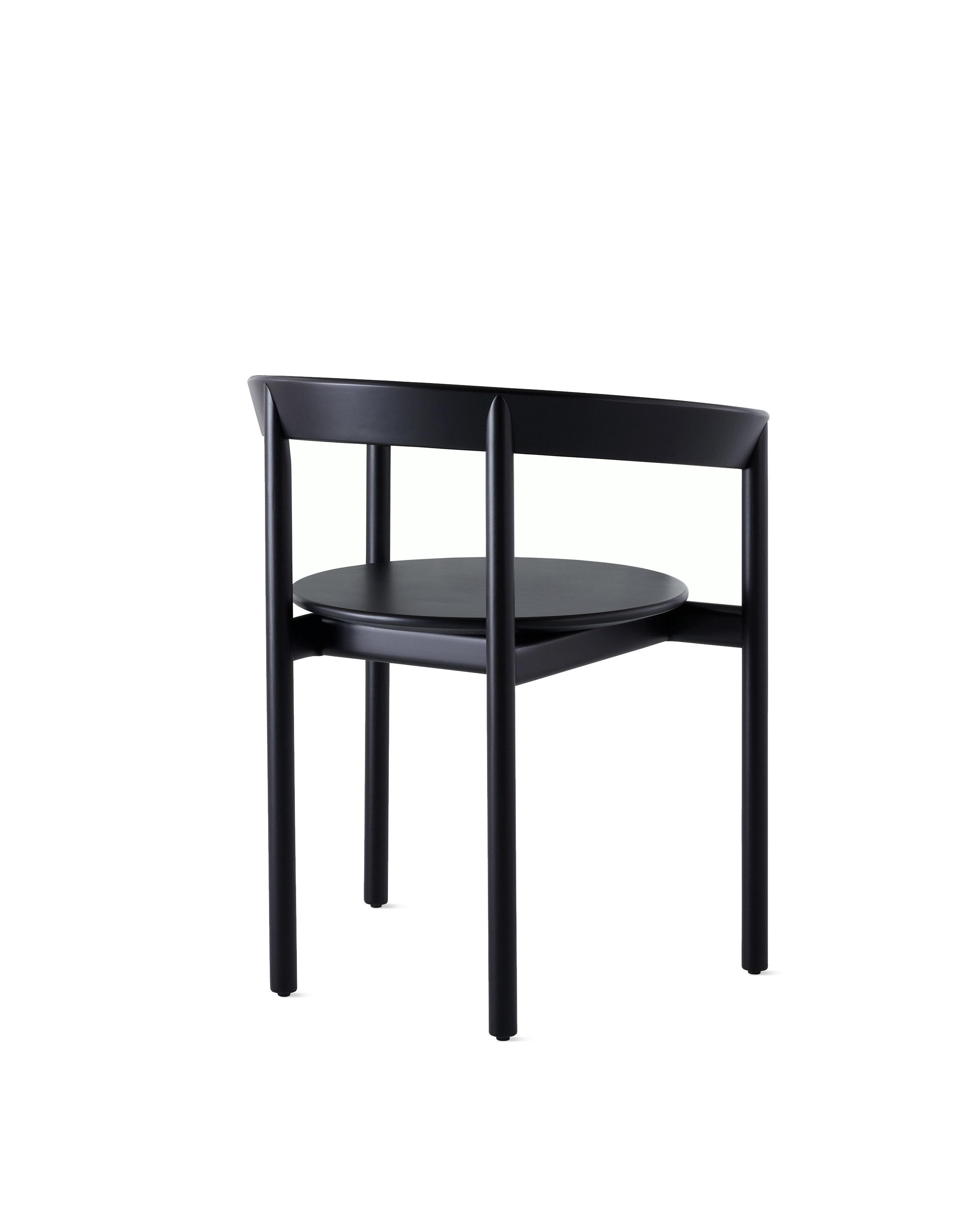 A black Comma Chair with arms, viewed from the back at an angle. 