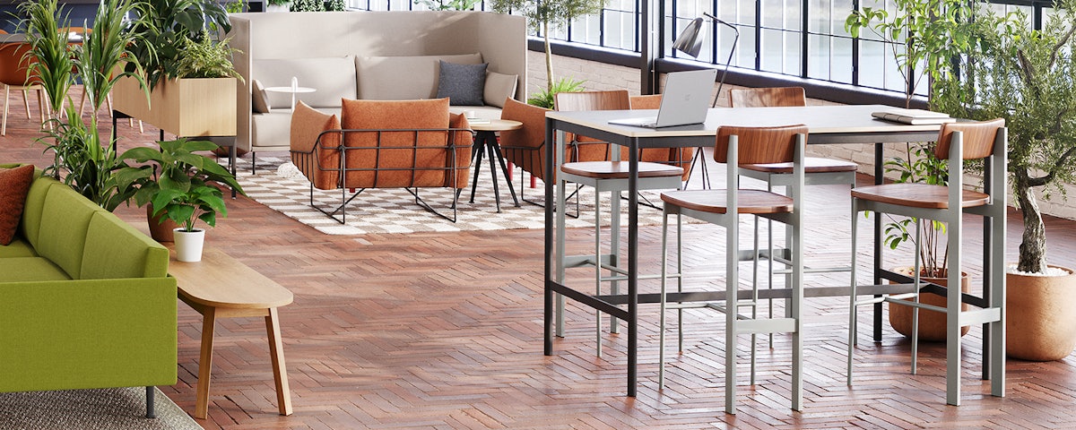 Four Betwixt Stools around a tall desk in a community space with other furniture items