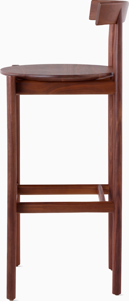 Profile view of a walnut bar-height Comma Stool.