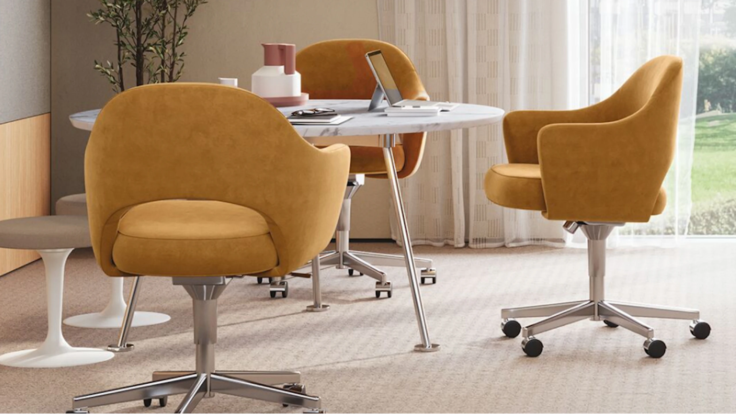 Three orange Saarinen Executive Chairs and two Saarinen Tulip Stools around a white Knoll Grasshopper Table in an individual private office setting designed to facilitate change