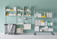 Medical soiled utility in soft white Co/Struc System including a sink and stainless steel wire shelving unit.